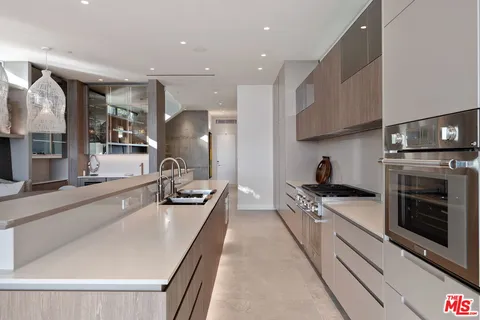 a large kitchen with stainless steel appliances granite countertop a lot of counter space