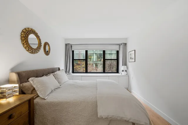 a bedroom with a bed and a large window