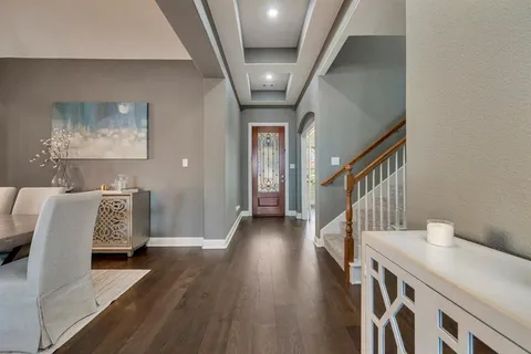a view of a hallway with wooden floor and stairs