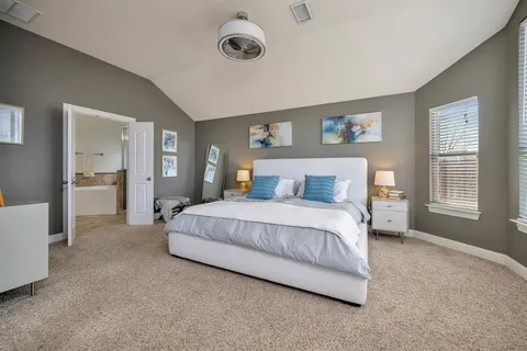 a spacious bedroom with a bed and a cabinets