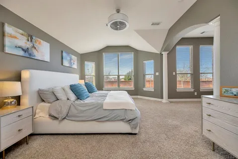 a spacious bedroom with a large bed and a large window