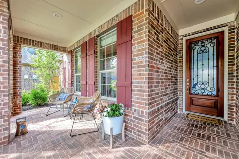 a view of a porch with chairs and potted plants