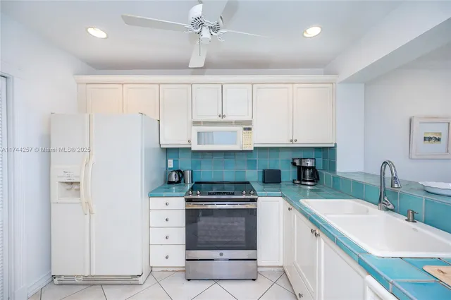 a kitchen with white cabinets and refrigerator