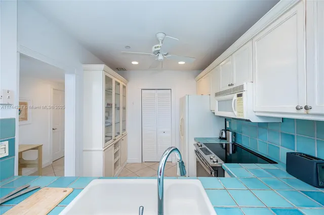 a kitchen with stainless steel appliances granite countertop a sink and a refrigerator