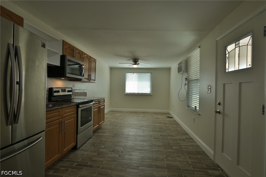 11 California Road Lehigh Acres, FL 33936 - Photo 6 of 19 a kitchen with granite countertop a refrigerator and a stove top oven