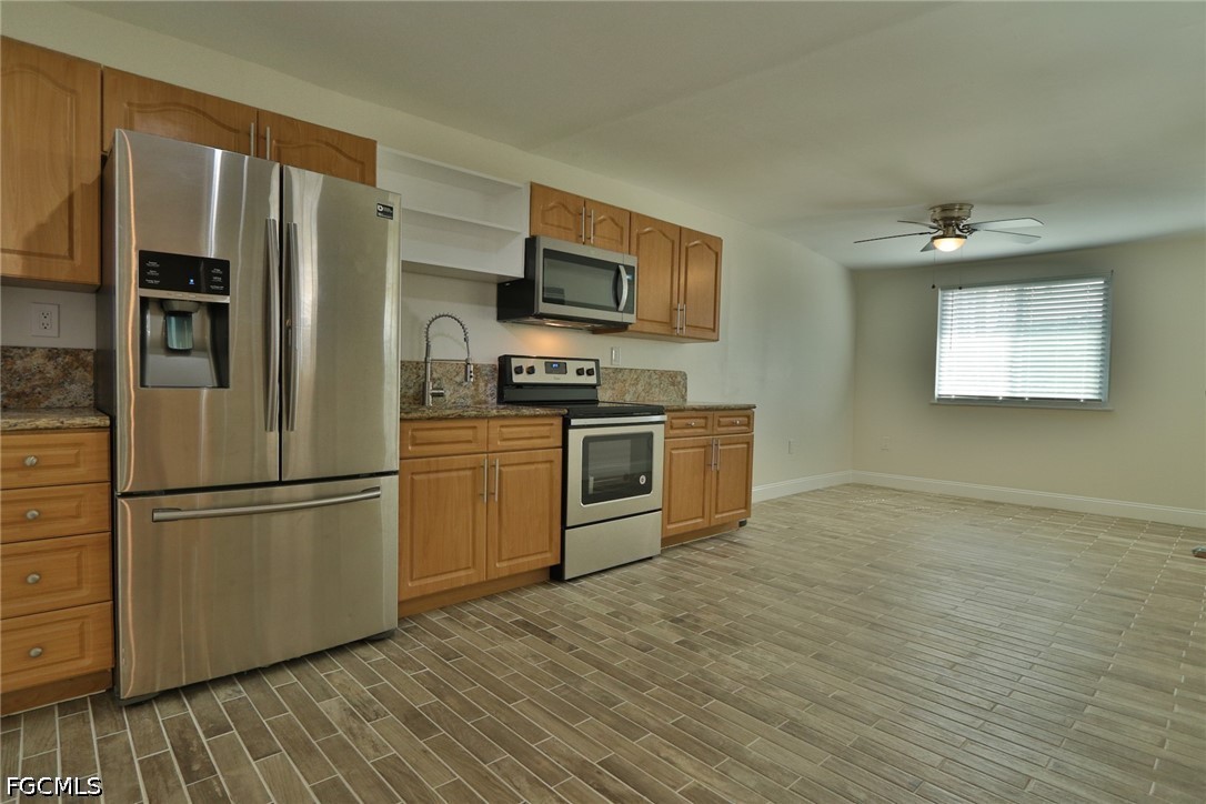 11 California Road Lehigh Acres, FL 33936 - Photo 7 of 19 a kitchen with stainless steel appliances granite countertop a refrigerator microwave and stove