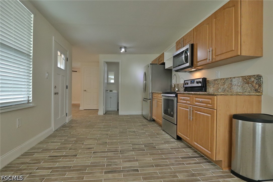 11 California Road Lehigh Acres, FL 33936 - Photo 10 of 19 a kitchen with stainless steel appliances granite countertop a stove a sink and a refrigerator
