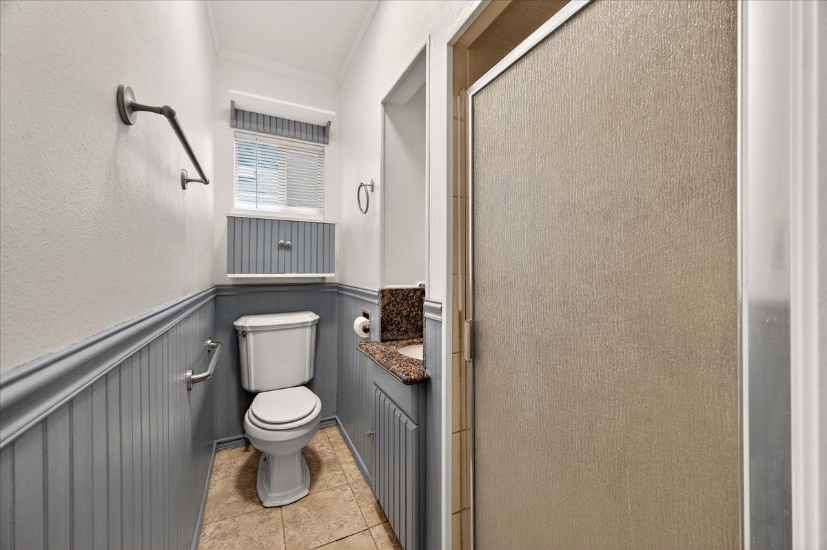 311 South K Street Madera, CA 93637 - Photo 11 of 46 a white toilet sitting next to a shower