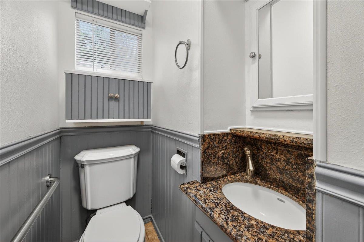 311 South K Street Madera, CA 93637 - Photo 12 of 46 a bathroom with a granite countertop toilet sink and mirror