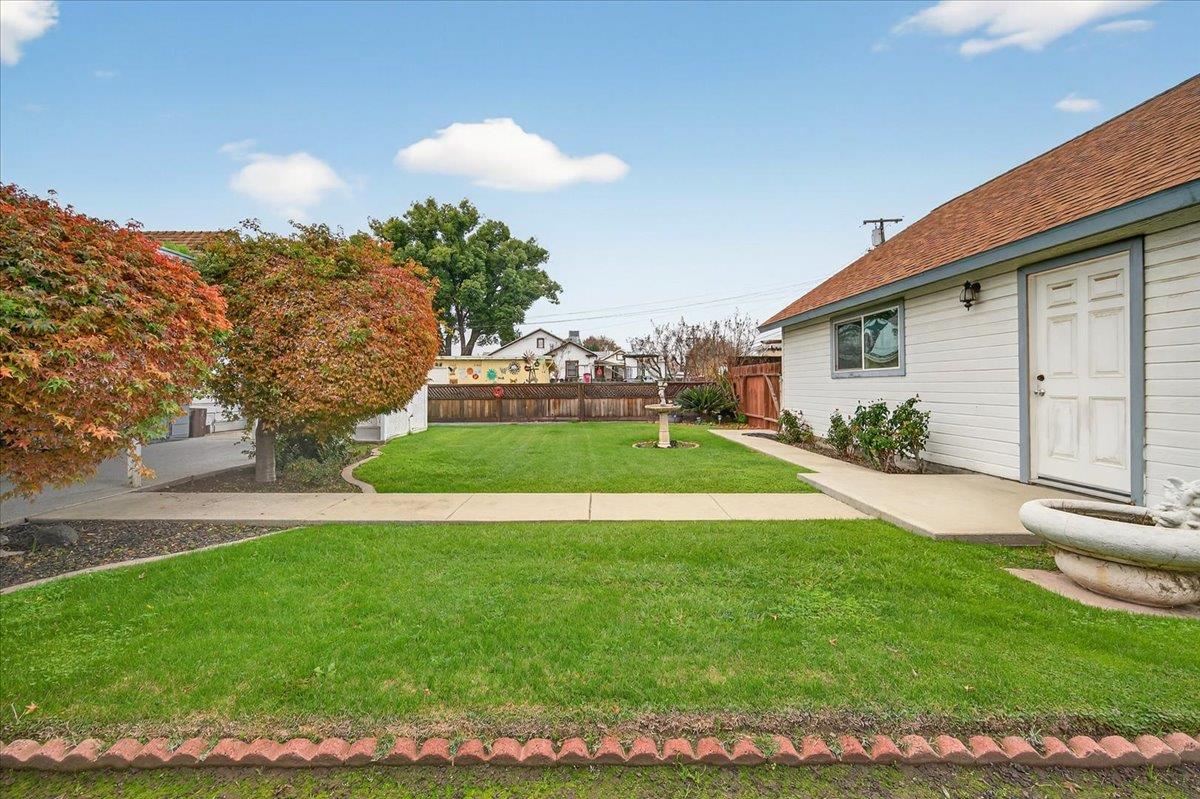 311 South K Street Madera, CA 93637 - Photo 21 of 46 a view of a house with a yard and a garden
