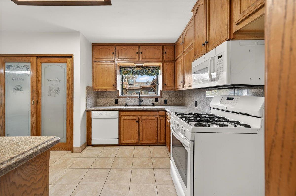 311 South K Street Madera, CA 93637 - Photo 39 of 46 a kitchen with stainless steel appliances granite countertop a stove a sink and a microwave