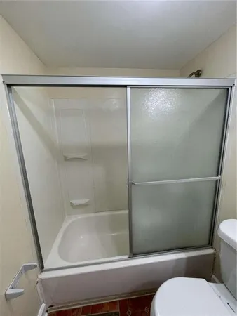a bathroom with a toilet and a shower