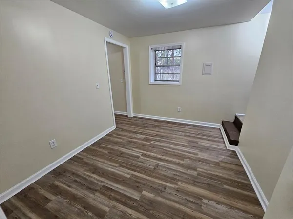 a view of a room with wooden floor and a window