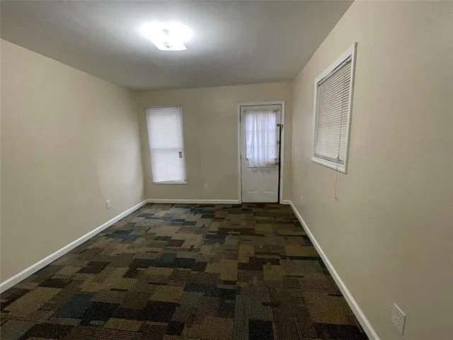 a view of a livingroom with wooden floor and a bathroom