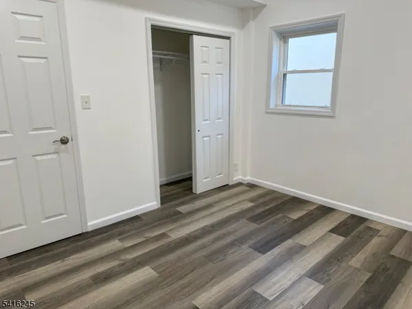 a view of a room with wooden floor and closet area
