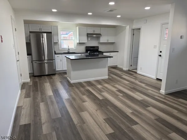 a kitchen with stainless steel appliances granite countertop a refrigerator and a sink