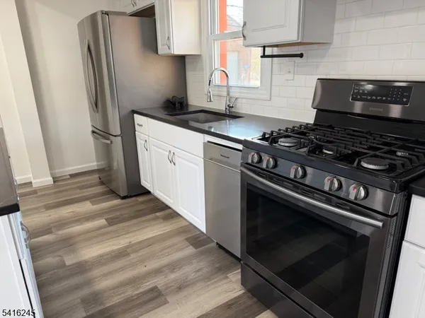 a kitchen with granite countertop a stove and a refrigerator