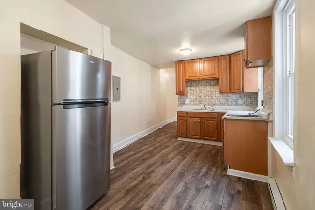 a kitchen with kitchen island granite countertop stainless steel appliances a refrigerator a sink and a stove top oven