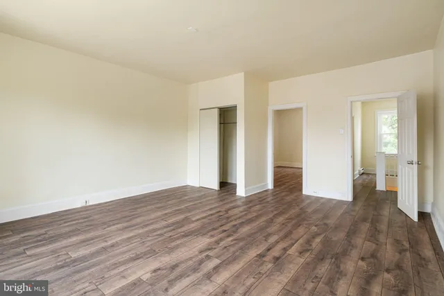 a view of empty room with wooden floor