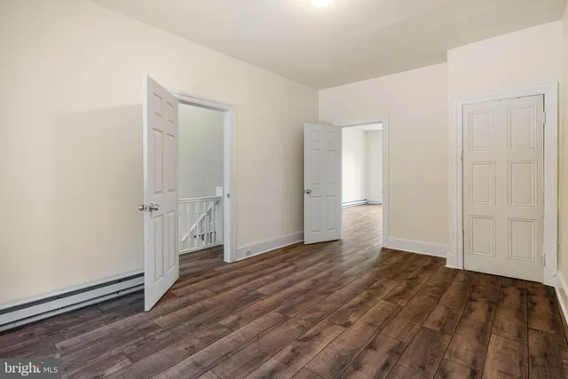 an empty room with wooden floor and door
