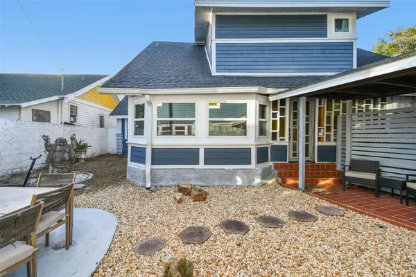 a view of a house with backyard sitting area and garden