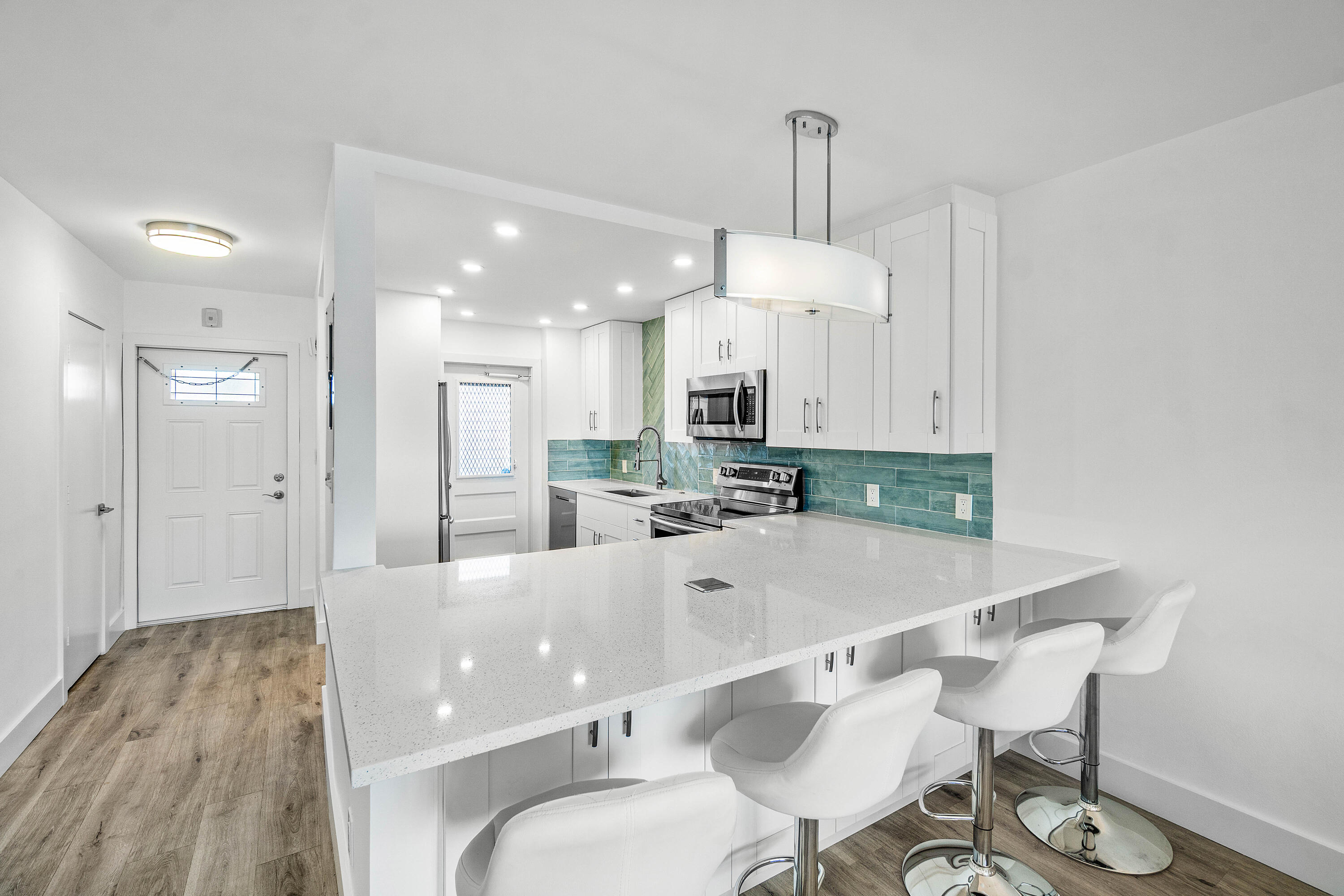 698 Northeast Spanish River Boulevard, Unit 140 Boca Raton, FL 33431 - Photo 3 of 21 a large white kitchen with a table and chairs