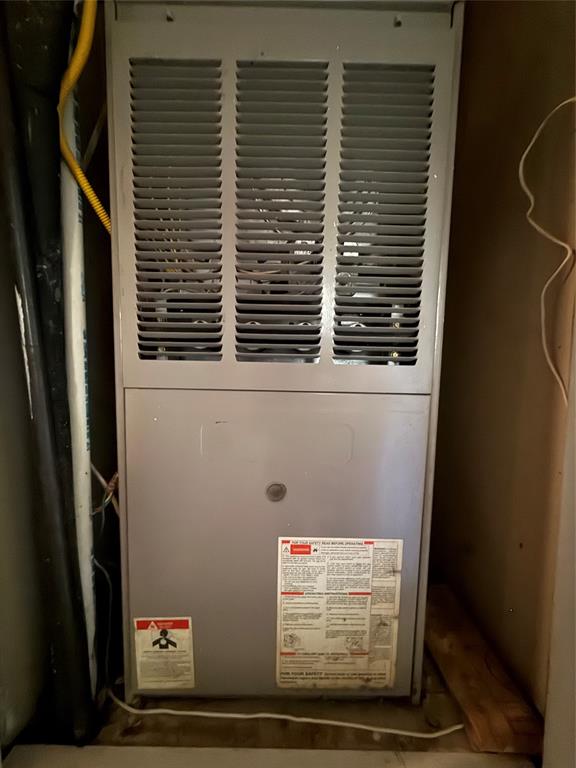 217 3rd St Pinehill Springhill, LA 71075 - Photo 21 of 23 Vertical furnace unit with a louvered top section, featuring a gray finish and visible warning labels