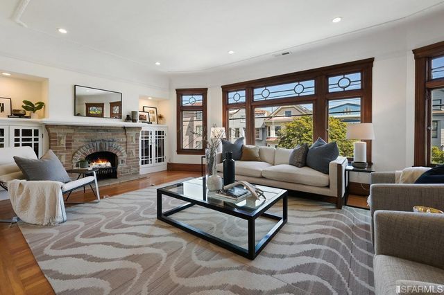 a living room with furniture large window and a fireplace