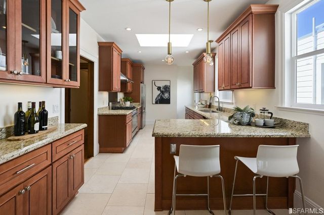 a kitchen with stainless steel appliances granite countertop table chairs sink and cabinets