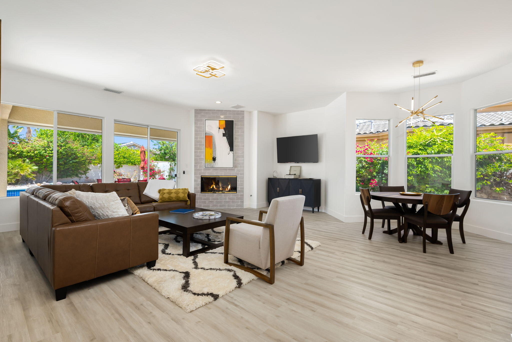 3 King Edward Court Rancho Mirage, CA 92270 - Photo 2 of 57 a living room with furniture floor to ceiling window hardwood floor and a flat screen tv