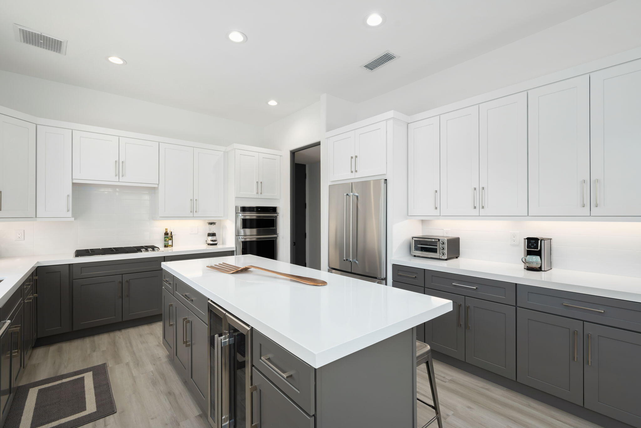 3 King Edward Court Rancho Mirage, CA 92270 - Photo 28 of 57 a kitchen with a sink a stove a refrigerator and white cabinets