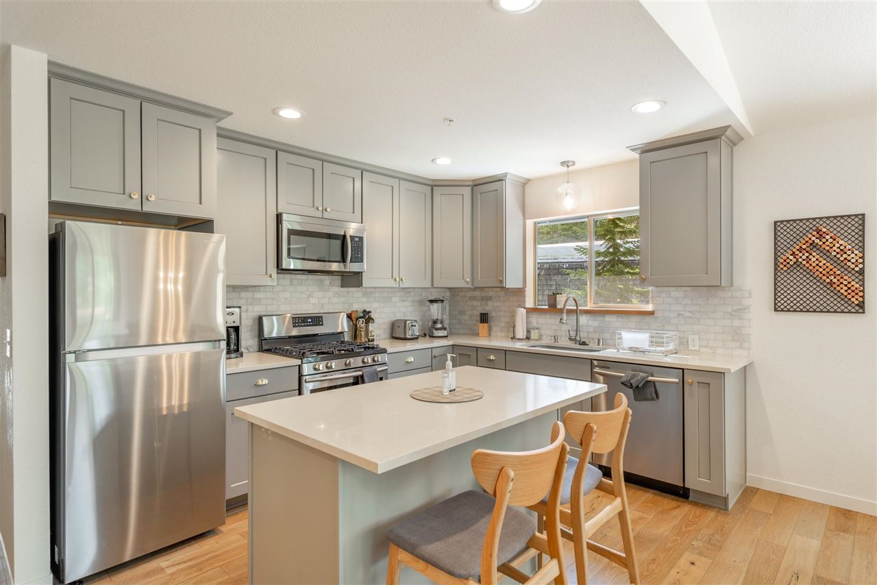 5641 Rhodesia Road Carnelian Bay, CA 96140 - Photo 8 of 21 a kitchen with stainless steel appliances granite countertop a sink a stove a refrigerator a microwave oven with cabinets and wooden floor