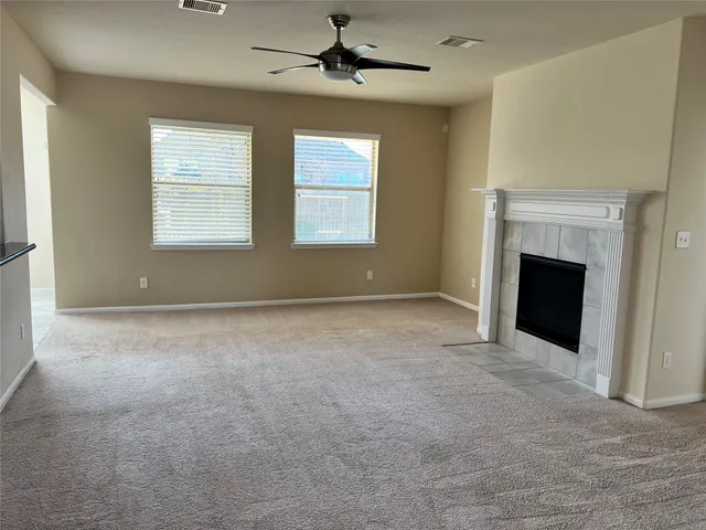 an empty room with windows and fireplace