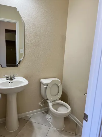 a bathroom with a toilet a sink and mirror