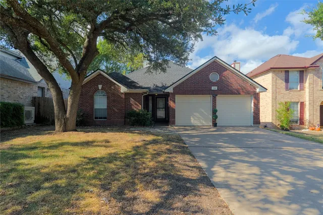 a front view of a house with yard and tree
