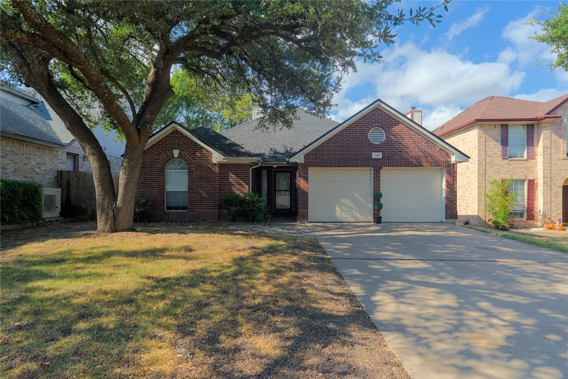 a front view of a house with yard and tree