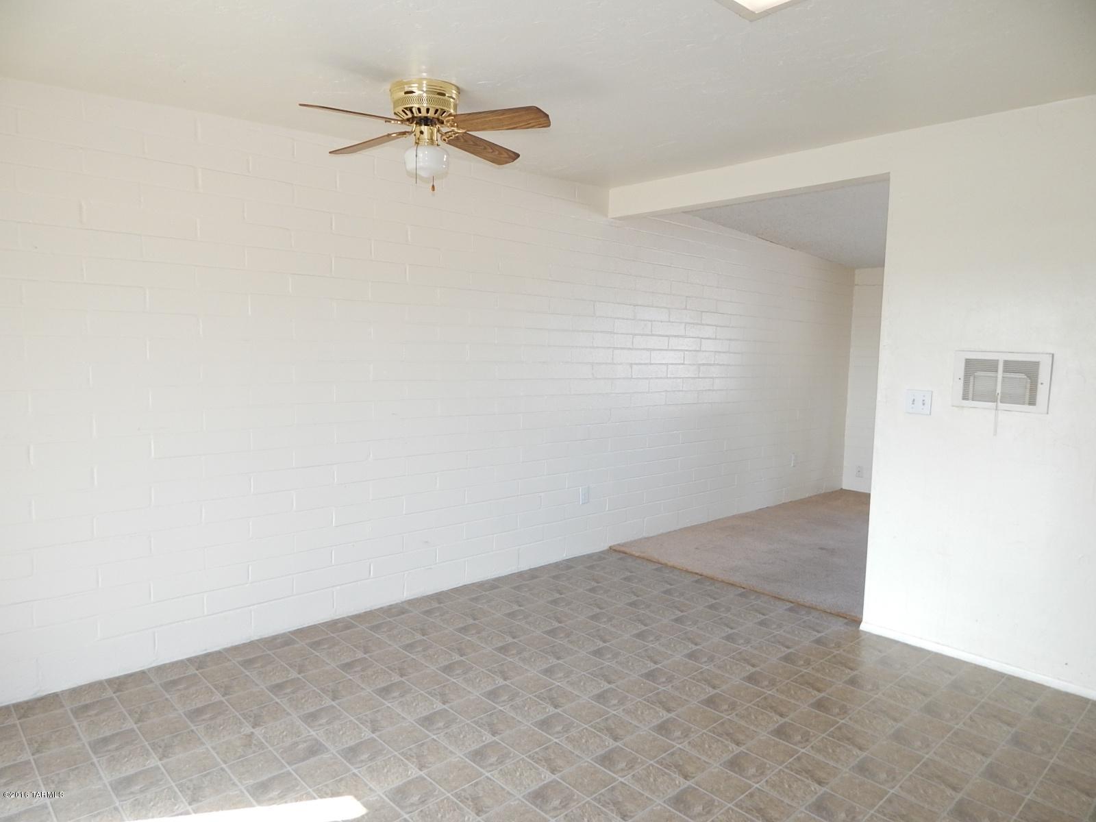 1527 West Roger Road Tucson, AZ 85705 - Photo 6 of 14 an empty room with a fan and a ceiling fan