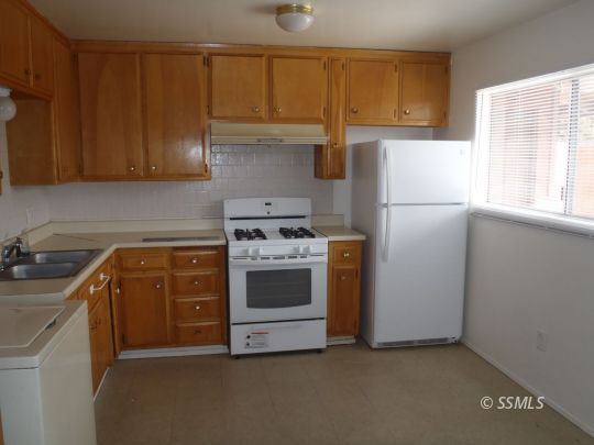 520 Commercial Avenue Ridgecrest, CA 93555 - Photo 3 of 15 a kitchen with a sink a stove and a refrigerator
