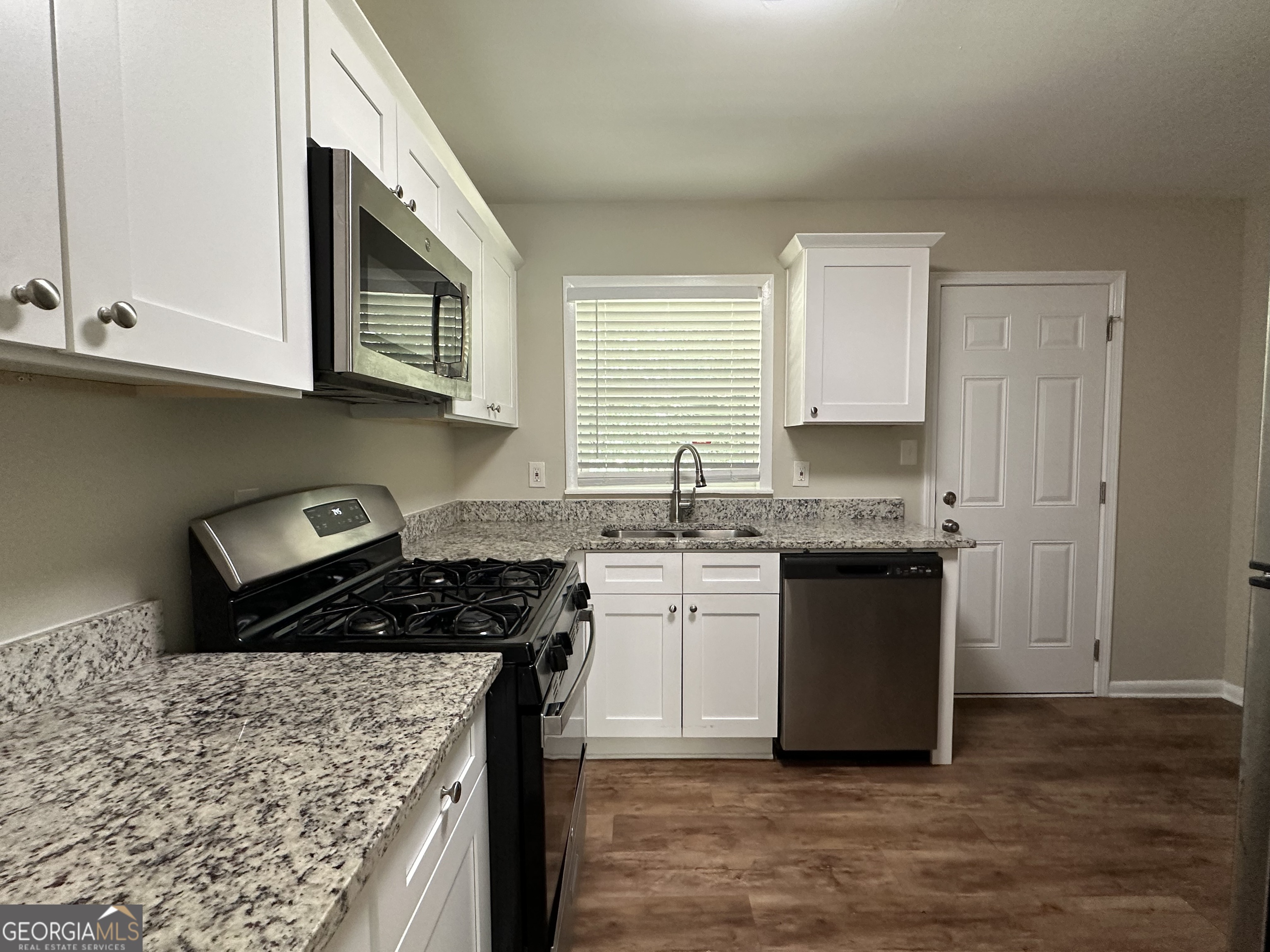 1154 Penn Court Southeast Atlanta, GA 30315 - Photo 3 of 9 a kitchen with stainless steel appliances granite countertop a stove a sink and a microwave
