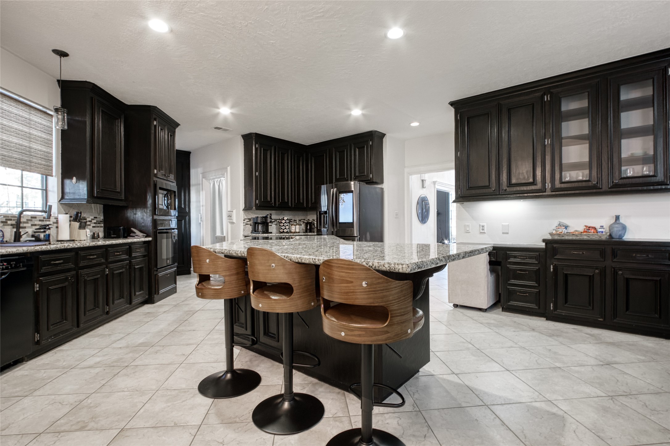 6782 Cutten Parkway Houston, TX 77069 - Photo 6 of 20 a kitchen with granite countertop a stove top oven a sink a dining table and chairs