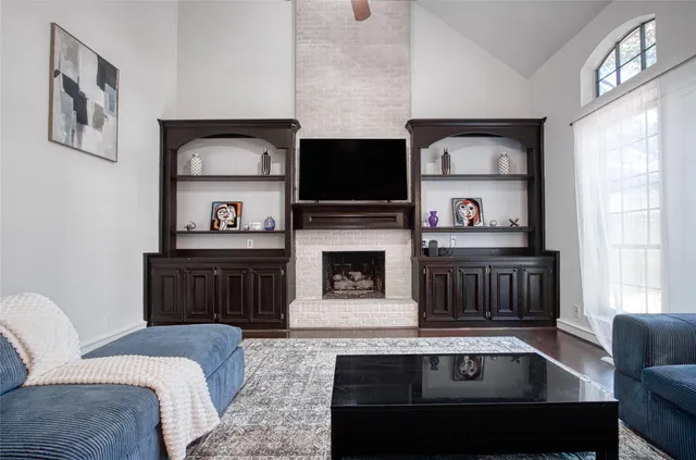 a living room with furniture a flat screen tv and a fireplace