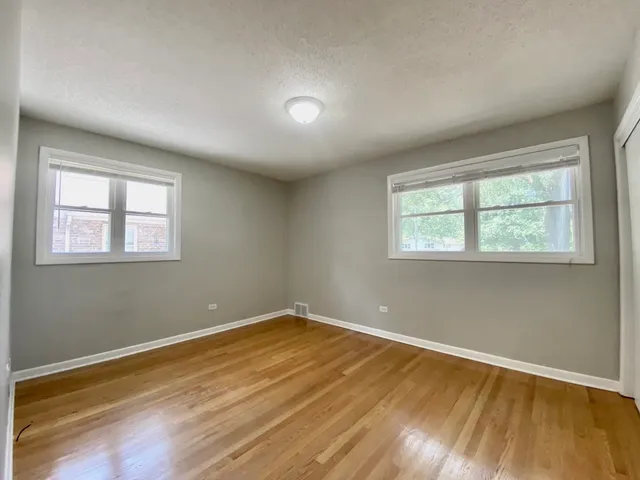 a view of a room with wooden floor and windows