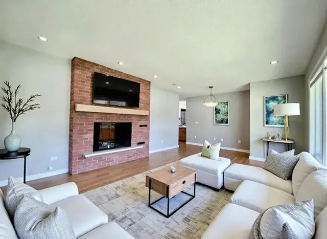 a living room with furniture a flat screen tv and a fireplace