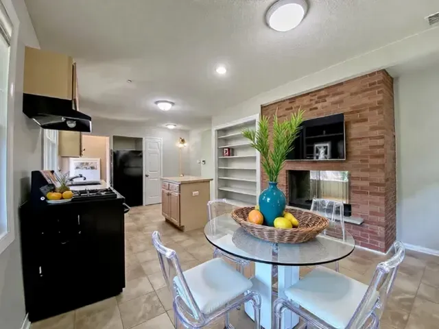 a kitchen with a sink refrigerator and chairs