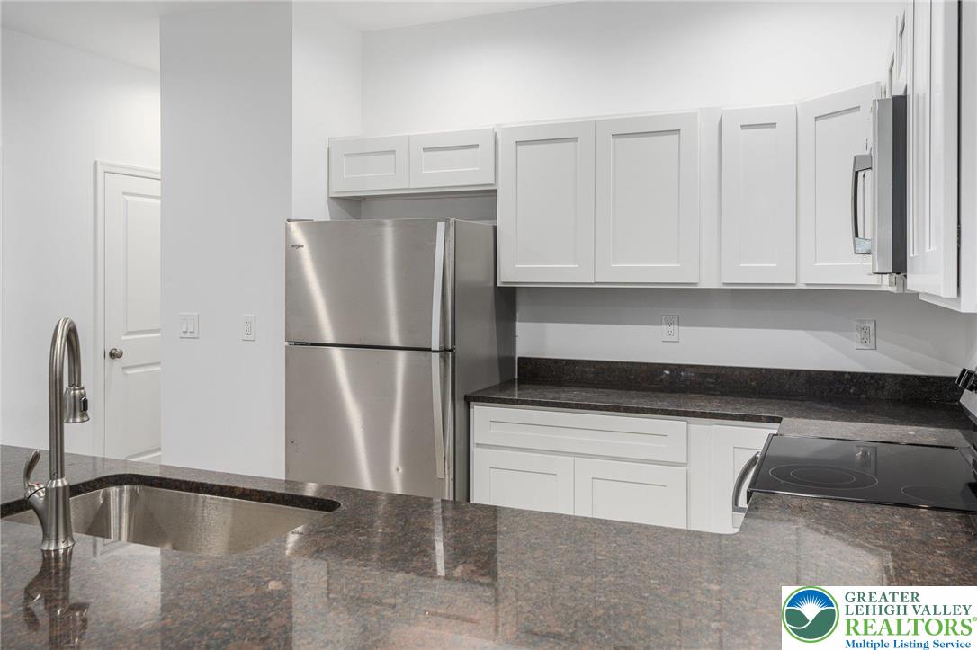 306 Barber Street, Unit LOT 39 Allentown, PA 18103 - Photo 14 of 30 a kitchen with granite countertop a refrigerator and a sink