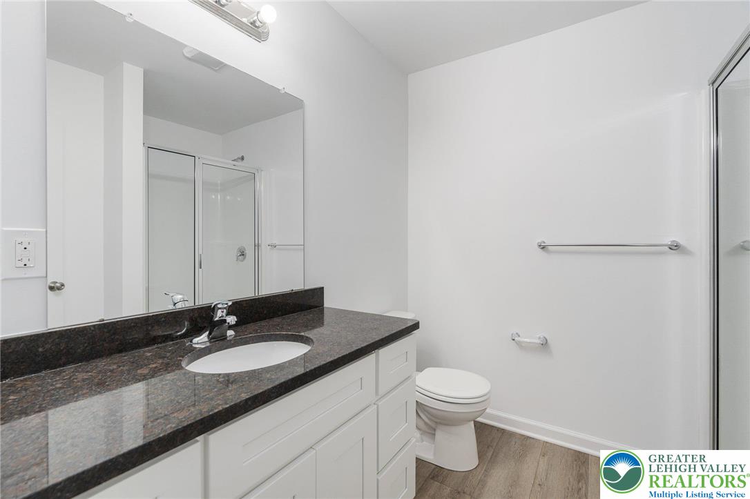 306 Barber Street, Unit LOT 39 Allentown, PA 18103 - Photo 22 of 30 a bathroom with a granite countertop sink a toilet and a mirror