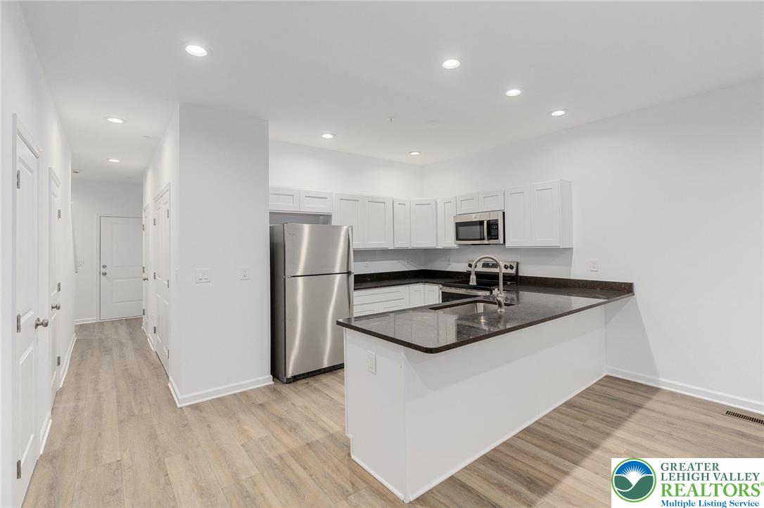 306 Barber Street, Unit LOT 39 Allentown, PA 18103 - Photo 7 of 30 a kitchen with stainless steel appliances granite countertop a sink and a refrigerator
