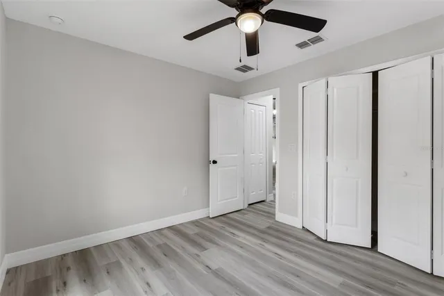a view of empty room with wooden floor and window