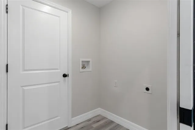 a large kitchen with kitchen island a stove a refrigerator a sink dishwasher and a oven with white cabinets