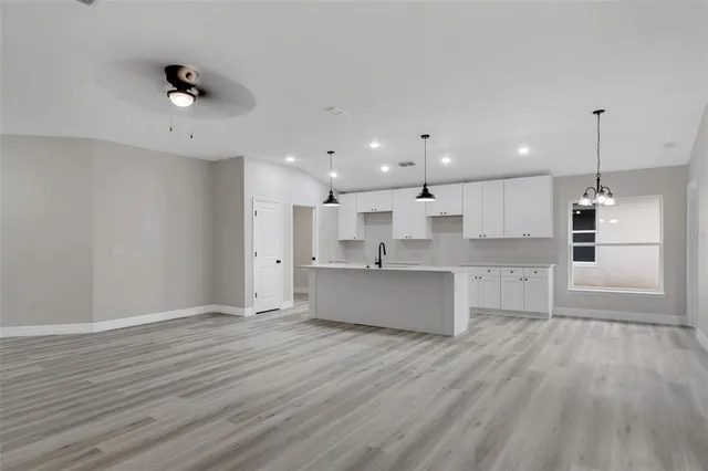 a view of a kitchen counter space a sink wooden floor and a window